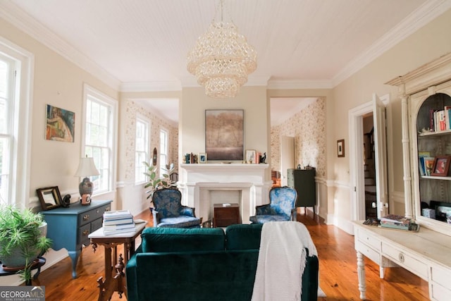 living area with a chandelier, crown molding, wood finished floors, and a fireplace