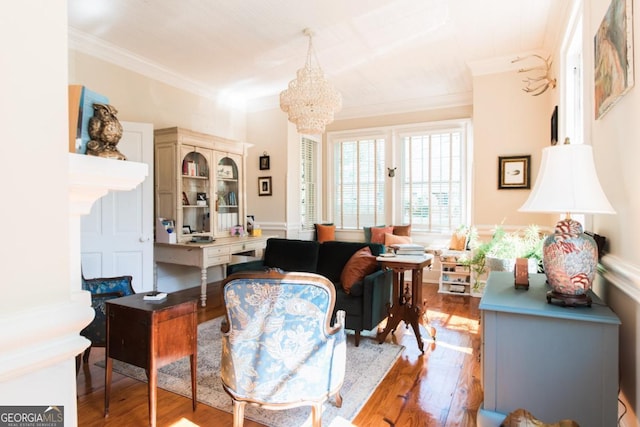 sitting room with wood finished floors, crown molding, and a chandelier