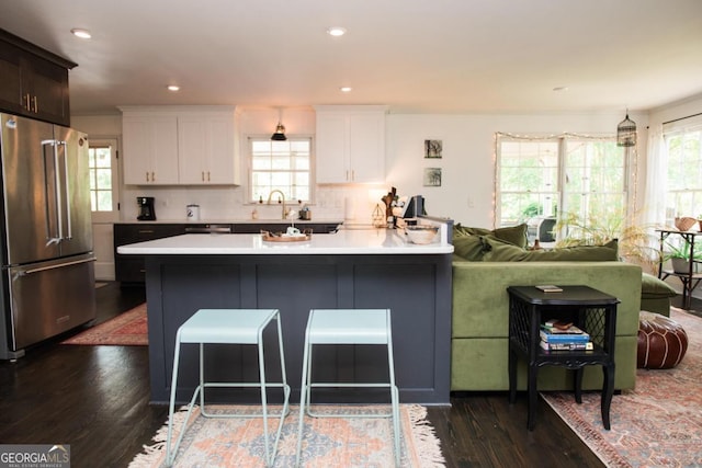 kitchen featuring high end fridge, dark wood-style floors, light countertops, white cabinets, and a peninsula