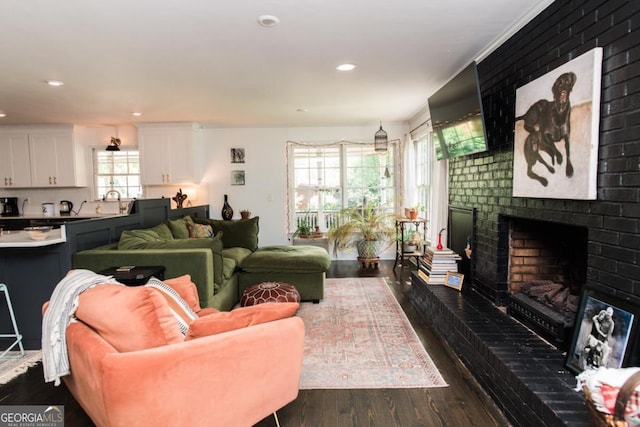 living area with dark wood-style floors, a fireplace, and recessed lighting
