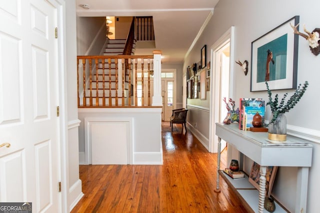 hall with wood finished floors, stairway, crown molding, and baseboards