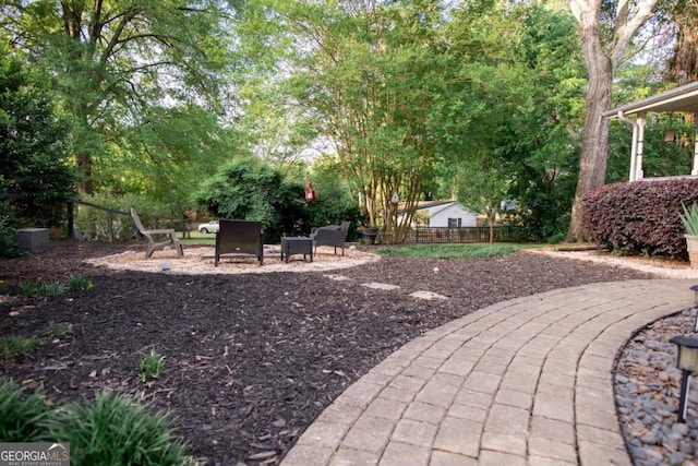 view of yard featuring a patio, fence, and view of scattered trees