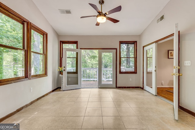 doorway with baseboards, ceiling fan, light tile patterned flooring, and vaulted ceiling