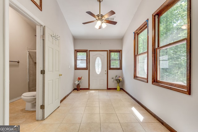 foyer featuring light tile patterned floors, ceiling fan, vaulted ceiling, and baseboards