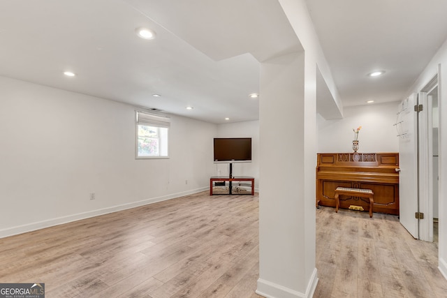 below grade area featuring light wood-style floors, recessed lighting, and baseboards