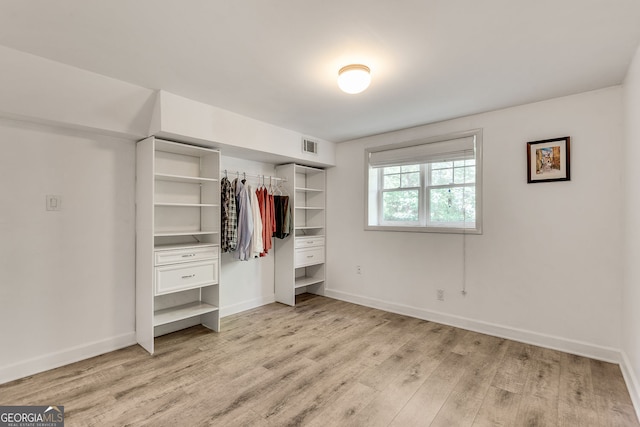 unfurnished bedroom featuring light wood finished floors, a closet, and baseboards
