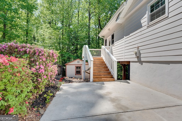 view of patio / terrace with a shed, an outbuilding, and stairway