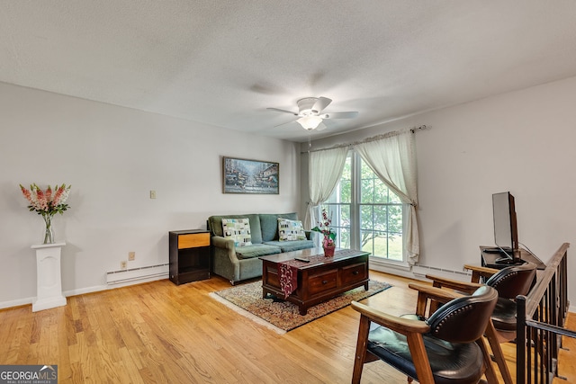 3990 Admiral Dr, Chamblee, GA 30341 - living area featuring a ceiling fan, light wood finished floors, a baseboard heating unit, a textured ceiling, and baseboards