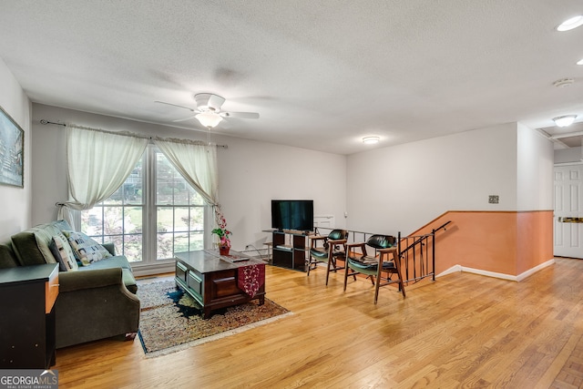 3990 Admiral Dr, Chamblee, GA 30341 - living room featuring light wood-type flooring, a ceiling fan, a textured ceiling, and baseboards