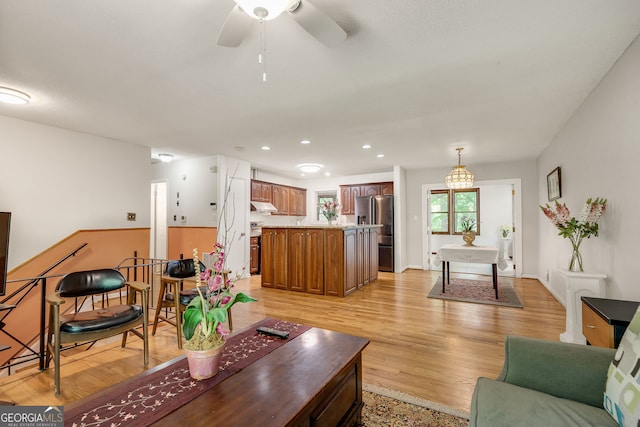 living area featuring a ceiling fan, recessed lighting, and light wood-style floors