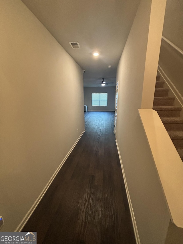 hallway featuring dark wood-style flooring, baseboards, recessed lighting, and stairs
