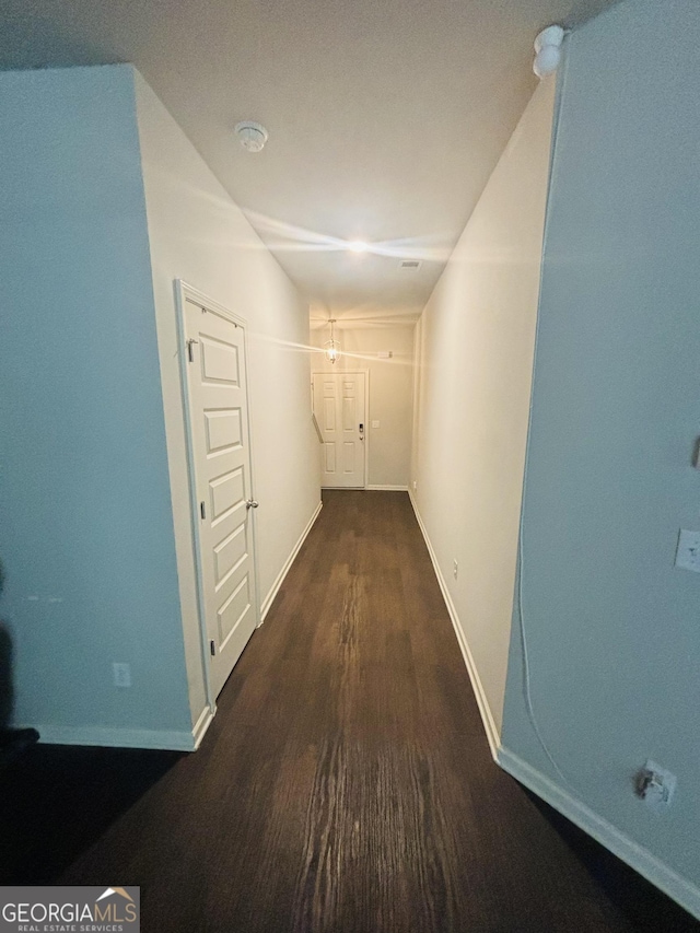 corridor with wood finished floors and baseboards