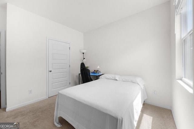 bedroom with multiple windows, baseboards, and light carpet