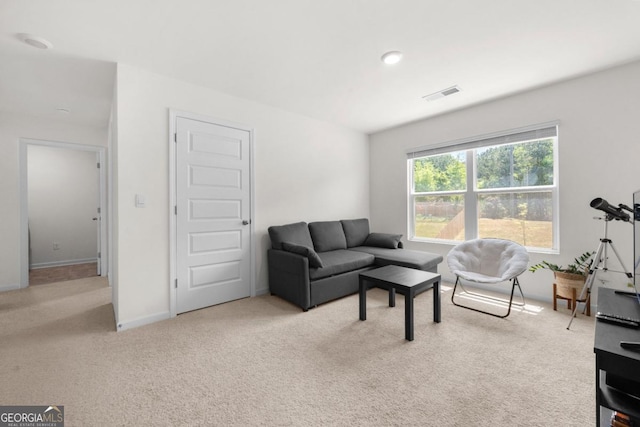 carpeted living area featuring baseboards and visible vents