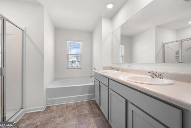 bathroom with a shower stall, baseboards, a bath, and a sink