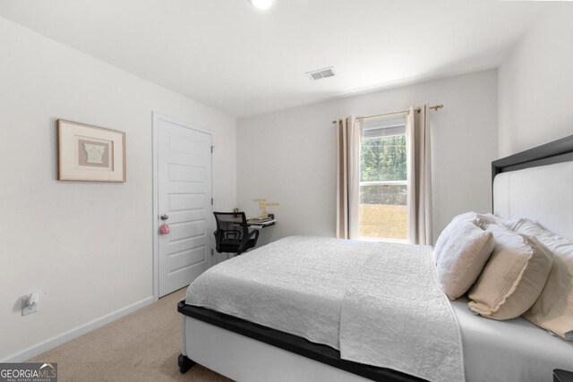 carpeted bedroom featuring baseboards and visible vents