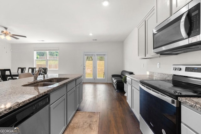 kitchen featuring a sink, open floor plan, stainless steel appliances, dark wood-style floors, and recessed lighting
