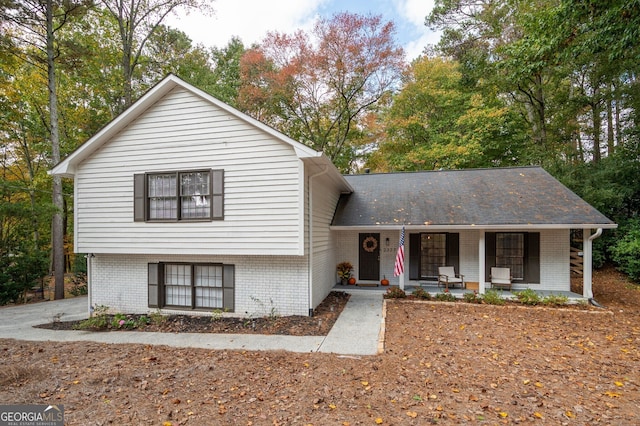 split level home with covered porch and brick siding