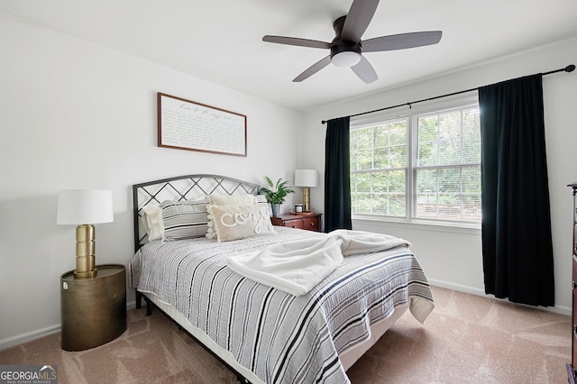 carpeted bedroom with ceiling fan and baseboards