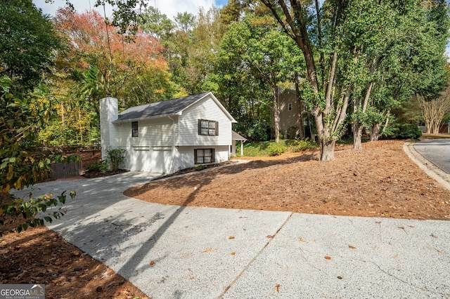view of home's exterior with a garage, driveway, and fence