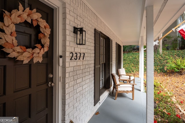 property entrance featuring brick siding and covered porch