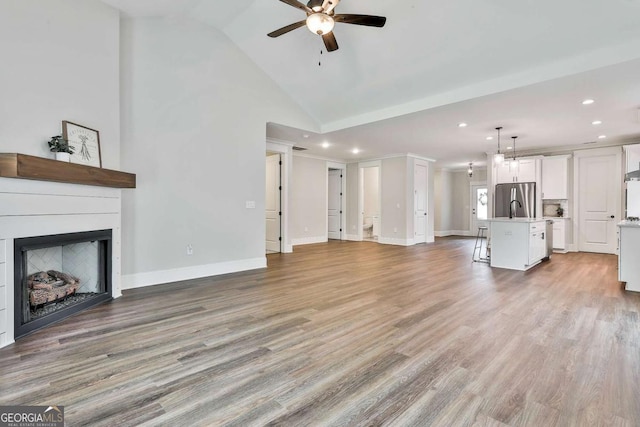 205 Farrell Creek Dr, Senoia, GA 30276 - unfurnished living room with a ceiling fan, recessed lighting, a fireplace, light wood-style flooring, and high vaulted ceiling