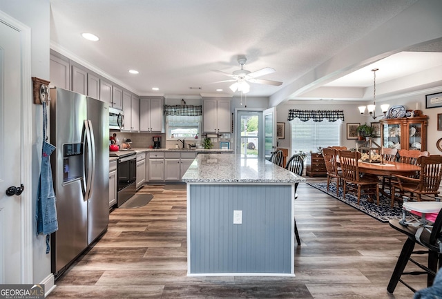 99 Mcmillian Ct, Winder, GA 30680 - kitchen featuring light stone counters, a sink, gray cabinetry, appliances with stainless steel finishes, and ceiling fan with notable chandelier