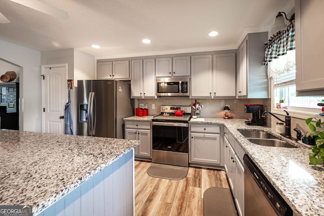 99 Mcmillian Ct, Winder, GA 30680 - kitchen with light wood finished floors, stainless steel appliances, light stone countertops, and a sink