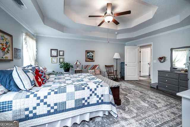 99 Mcmillian Ct, Winder, GA 30680 - bedroom with crown molding, wood finished floors, ceiling fan, a tray ceiling, and visible vents