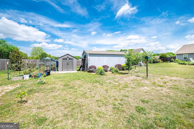 99 Mcmillian Ct, Winder, GA 30680 - view of yard featuring fence, a greenhouse, an outbuilding, and a storage unit
