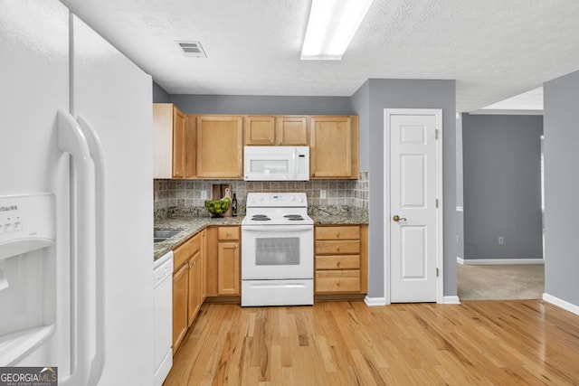 1220 Skipping Rock Ln SW, Grayson, GA 30017 - kitchen with light wood-style floors, backsplash, white appliances, and visible vents