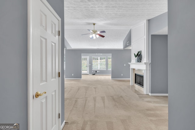 1220 Skipping Rock Ln SW, Grayson, GA 30017 - unfurnished living room with baseboards, ceiling fan, light colored carpet, a textured ceiling, and a large fireplace