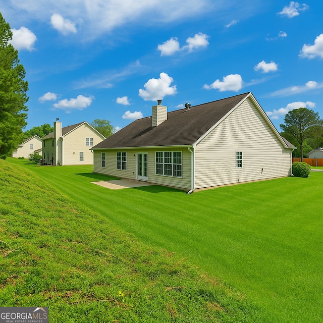 1220 Skipping Rock Ln SW, Grayson, GA 30017 - back of property featuring a lawn, a patio, and a chimney