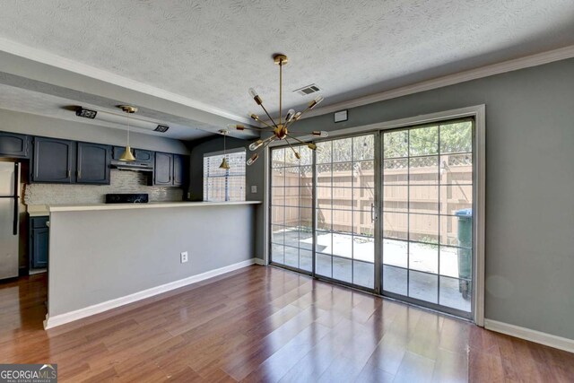 interior space featuring dark wood-style floors, visible vents, baseboards, freestanding refrigerator, and an inviting chandelier