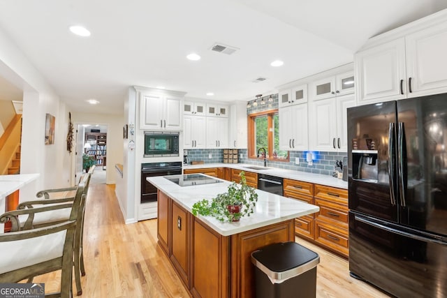 4761 Gateway Ln, Flowery Branch, GA 30542 - kitchen with black appliances, light wood-style floors, backsplash, white cabinetry, and recessed lighting