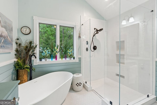 full bath with a stall shower, a sink, a freestanding tub, and vaulted ceiling