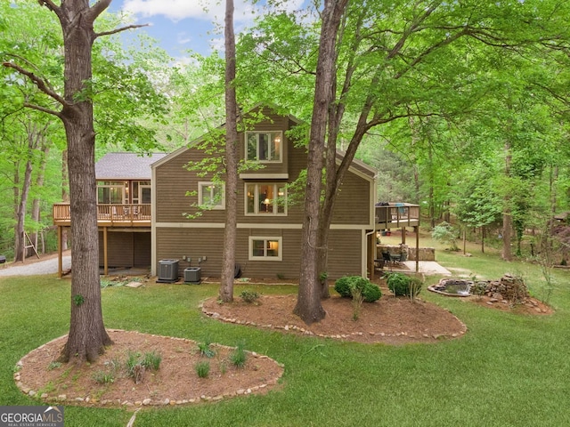 exterior space featuring a patio, a wooden deck, cooling unit, and a yard