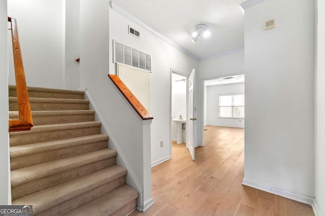 406 Vinings Forest Cir SE, Smyrna, GA 30080 - staircase with a textured ceiling, baseboards, visible vents, wood finished floors, and ornamental molding