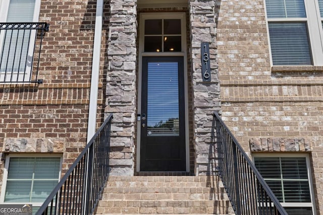 property entrance featuring brick siding