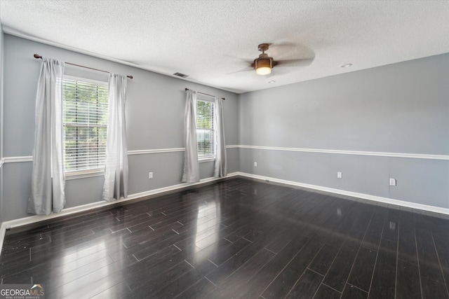 spare room featuring wood finished floors, a textured ceiling, ceiling fan, baseboards, and visible vents