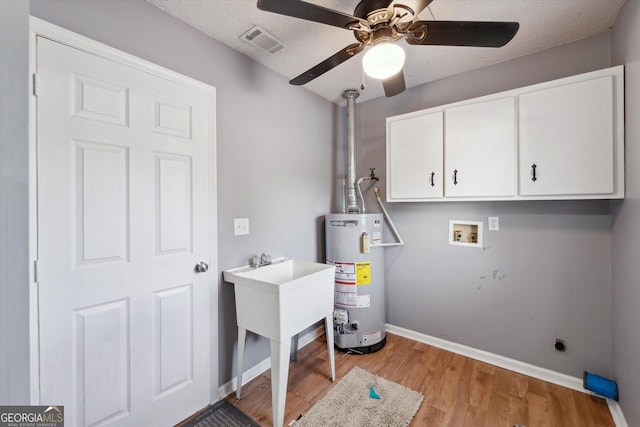 laundry area featuring a ceiling fan, cabinet space, gas water heater, visible vents, and washer hookup