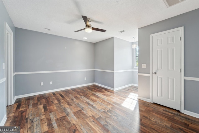 unfurnished bedroom featuring a textured ceiling, visible vents, baseboards, a ceiling fan, and wood finished floors