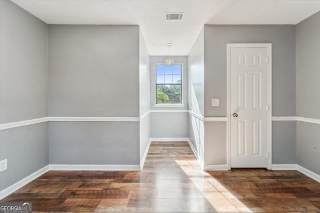 foyer entrance featuring hardwood / wood-style floors, visible vents, and baseboards
