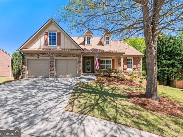 2402 Jasmine Glen Dr, Buford, GA 30519 - craftsman house featuring an attached garage, board and batten siding, driveway, stone siding, and a front yard