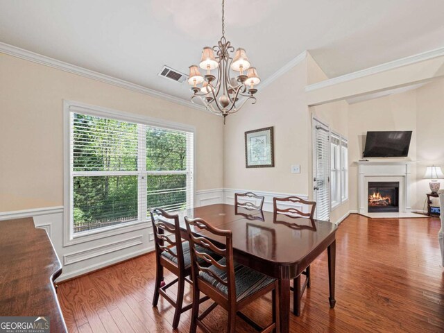 2402 Jasmine Glen Dr, Buford, GA 30519 - dining room with a wainscoted wall, visible vents, a chandelier, wood finished floors, and crown molding