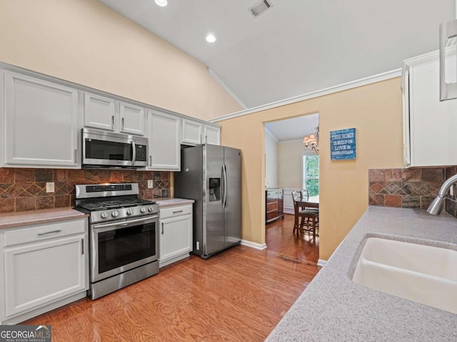 2402 Jasmine Glen Dr, Buford, GA 30519 - kitchen featuring vaulted ceiling, a sink, stainless steel appliances, light wood-style flooring, and visible vents