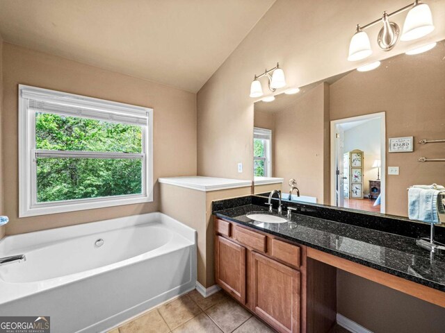2402 Jasmine Glen Dr, Buford, GA 30519 - bathroom featuring vaulted ceiling, a garden tub, tile patterned floors, and vanity