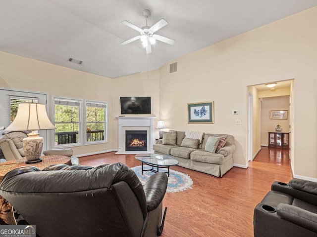 2402 Jasmine Glen Dr, Buford, GA 30519 - living area with wood finished floors, ceiling fan, a lit fireplace, and high vaulted ceiling