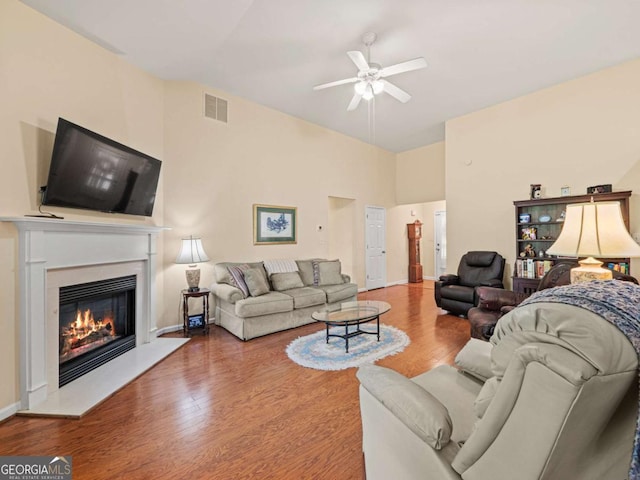 2402 Jasmine Glen Dr, Buford, GA 30519 - living room featuring wood finished floors, a glass covered fireplace, ceiling fan, baseboards, and visible vents