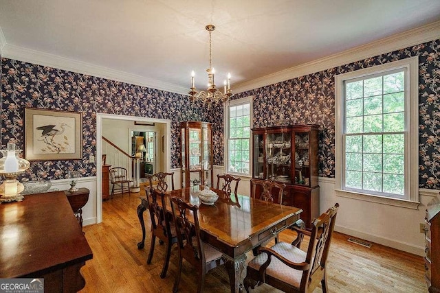 835 Timothy Rd, Athens, GA 30606 - dining area with wallpapered walls, light wood-style flooring, and an inviting chandelier